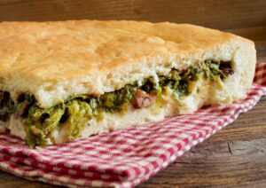 La pizza ripiena di broccoli e salsiccia: l’antipasto delle feste che profuma di tradizione