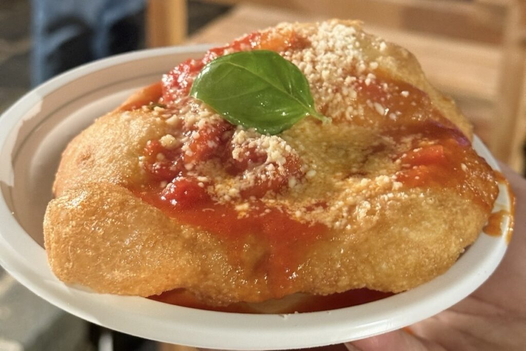 La tradizione che sfrigola: la pizza fritta napoletana con pomodoro e formaggio